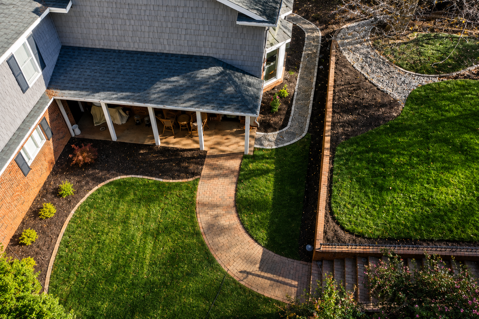 Landscaping crew installing a river-rock drainage channel in a wooded property